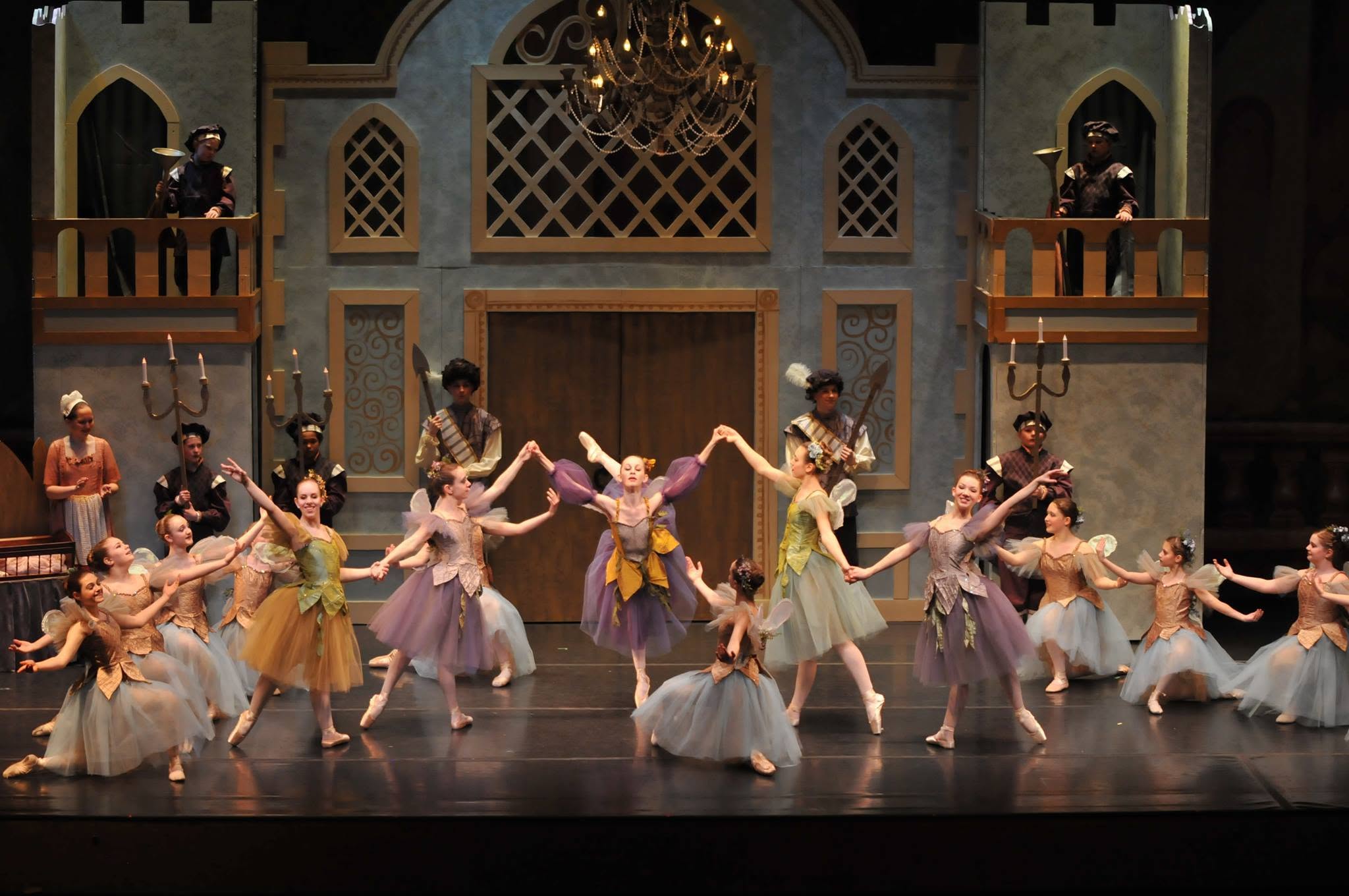 Ballet dancers in tailored fairy-tale costumes on a castle stage set