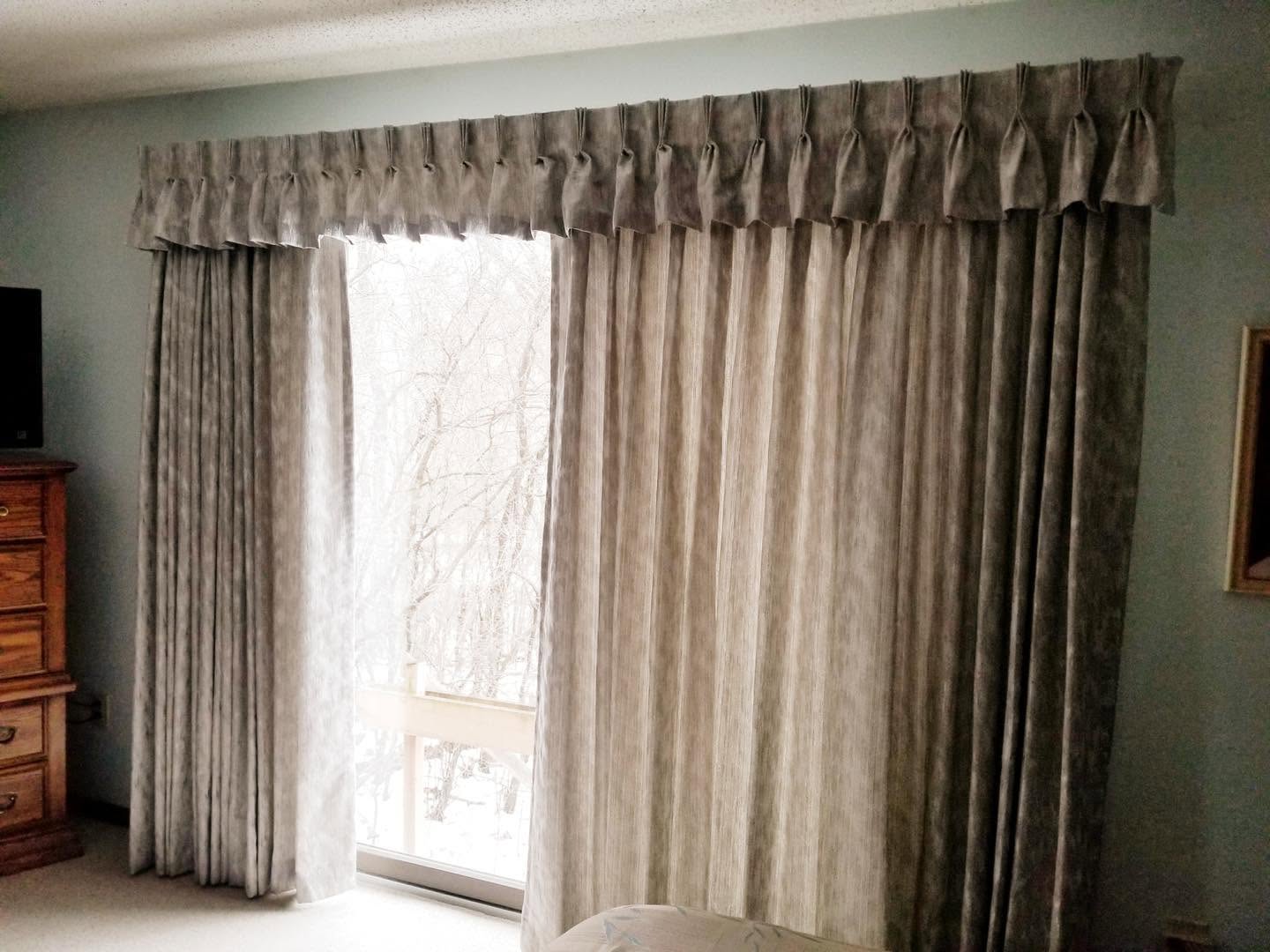 Floor-length pleated drapes with a matching valance over a large window